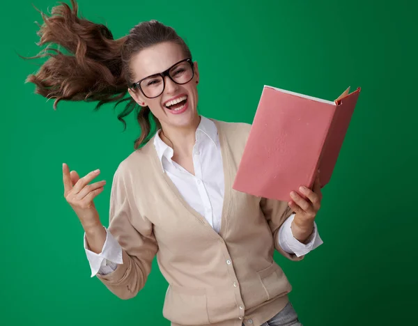 緑の背景にジャンプの本で陽気な若い学生女性 — ストック写真