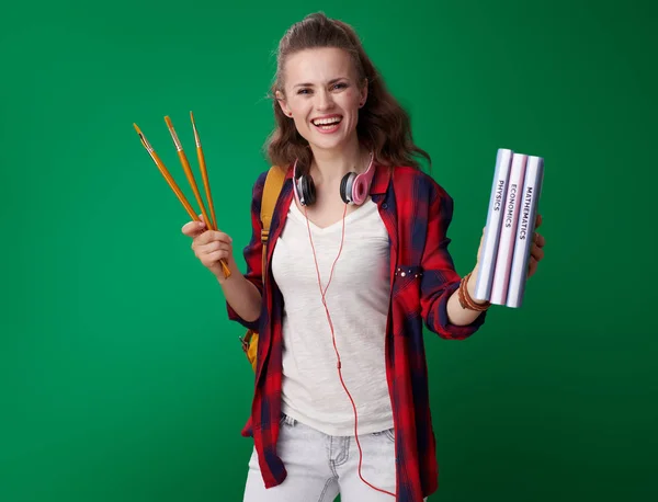 Щаслива Молода Студентка Червоній Сорочці Рюкзаком Навушниками Тримає Книги Пензлі — стокове фото