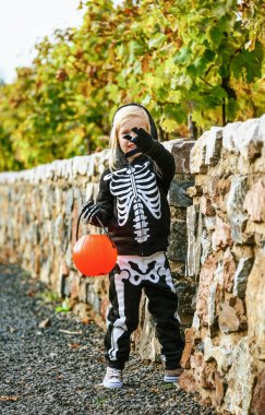  Cadılar Bayramı'nda kabak Jack O Lantern sepet açık havada tutan iskelet kostüm giyen çocuk 