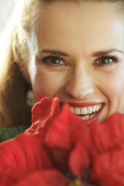 Sonriente Joven Ama Casa Sosteniendo Rojo Poinsettia Cerca Cara Primer —  Fotos de Stock