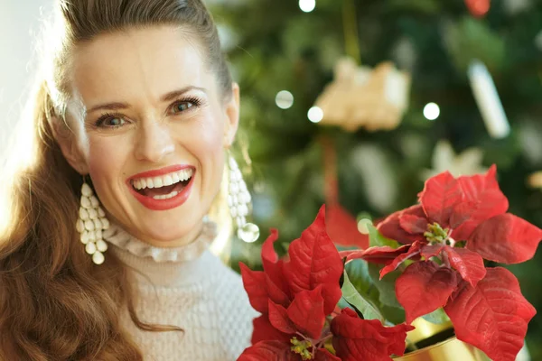 Gelukkig Moderne Huisvrouw Buurt Van Kerstboom Weergegeven Rode Poinsettia — Stockfoto