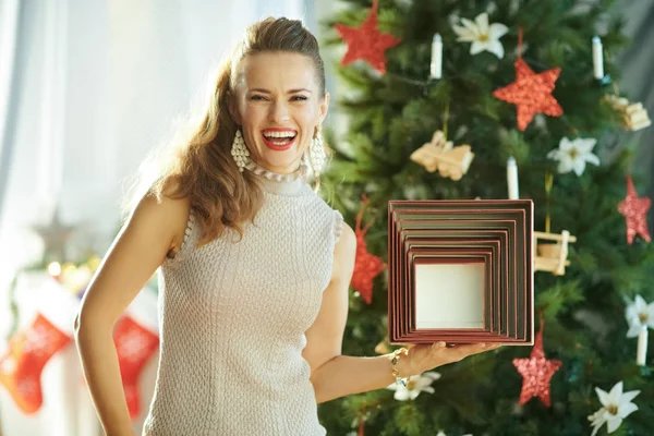 Счастливая Молодая Женщина Возле Елки Показывает Коробку Рождественского Подарка — стоковое фото