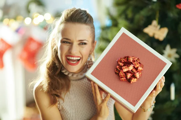 クリスマス ツリー クリスマス プレゼント ボックスを揺れ近く若い主婦の笑顔 — ストック写真
