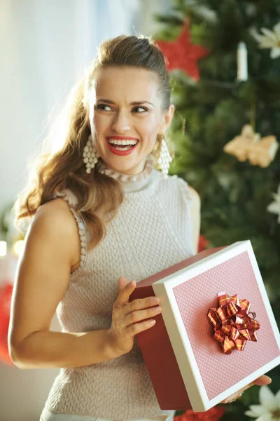 クリスマス プレゼント ボックスよそ見クリスマス ツリーの近くでトレンディな主婦の笑顔 — ストック写真