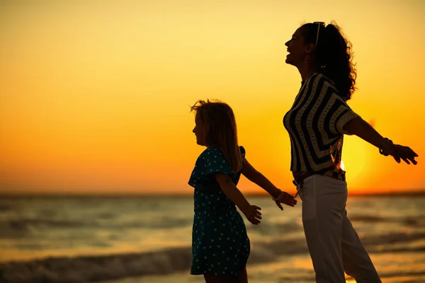 Lykkelig Mor Datter Nyder Sommerferier Mens Står Stranden Ved Solnedgang - Stock-foto