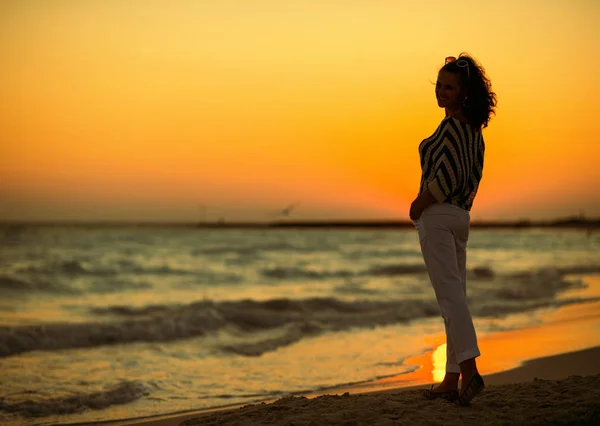 夏の夜の海岸に立っている現代の女性の完全な長さの肖像画 — ストック写真