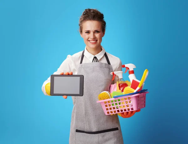 Smiling Young Housemaid Apron Basket Detergents Brushes Showing Tablet Blank — Stock Photo, Image