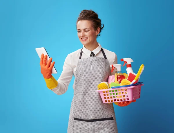 Smiling Young Cleaning Woman Apron Basket Cleansers Brushes Using Tablet — Stock Photo, Image