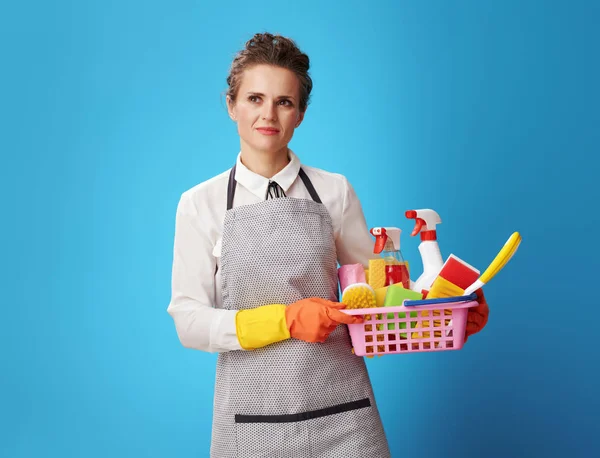 Portrait Pensive Young Cleaning Lady Apron Basket Detergents Brushes Isolated — Stock Photo, Image