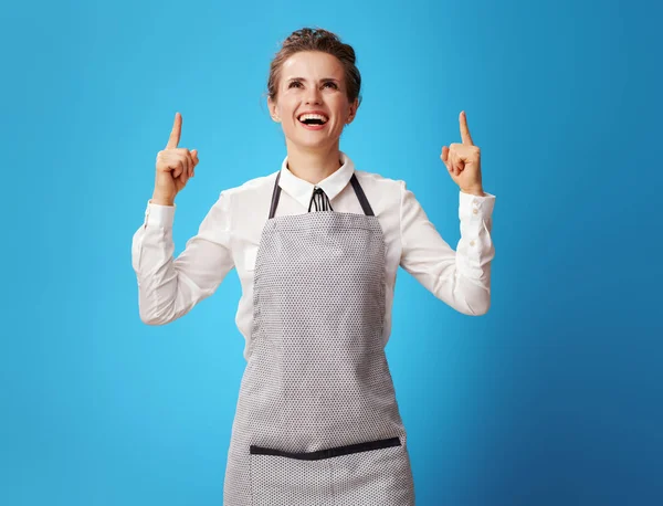 Happy Young Scrubwoman Apron Pointing Copy Space Blue Background Professional — Stock Photo, Image