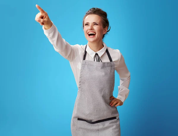 Smiling Young Scrubwoman Apron Pointing Something Blue Background Scrubwoman Shows — Stock Photo, Image