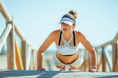 gücü program performans ve sahilde ahşap geçit, şınav fitness kadın