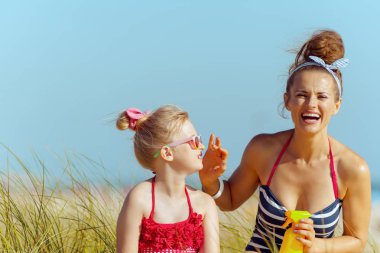 Modern anne ve çocuk beachwear sahilde Spf. güneş kremi yüksekliği Spf geniş Uv Uvb en fazla güneş yanığı koruma ile uygulama içinde gülümseyen.
