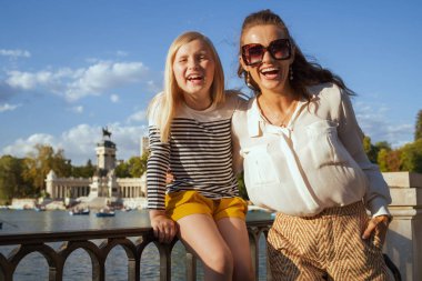 Mutlu son moda anne ve çocuk turist El Retiro Park Madrid, İspanya portresi. Madrid İspanya güneşli başkentidir. bir küresel seyahati tercih edilen hedef. çit oturan çocuk
