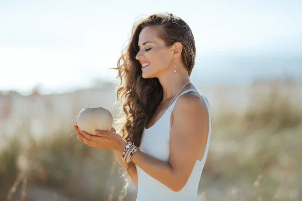 Mulher Moderna Sorridente Maiô Branco Costa Oceânica Segurando Coco Coco — Fotografia de Stock