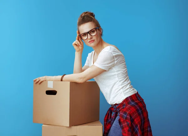 Porträtt Ung Kvinna Vit Shirt Nära Pappkartonger Mot Blå Bakgrund — Stockfoto