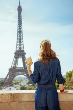 Mavi Jeans genel trendy turist kadınla kahve Kupası Paris, Fransa'da arkasından gördüm.