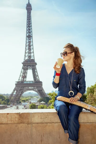 在法国巴黎 穿着蓝色牛仔裤的快乐时尚旅游妇女 与面包喝咖啡 — 图库照片