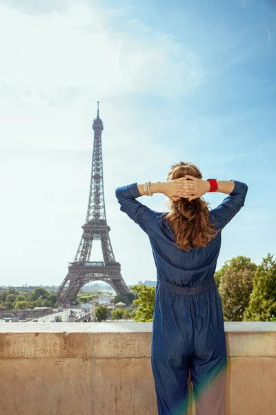 从后面看到 在法国巴黎 穿着蓝色牛仔裤的时尚女在巴黎埃菲尔铁塔的比赛中总体上 — 图库照片