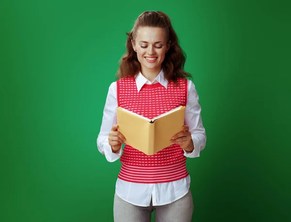 Studente donna lettura libro contro lavagna sfondo verde — Foto Stock