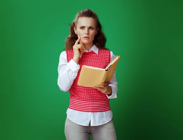 Student vrouw met gele boek over schoolbord groene achtergrond — Stockfoto