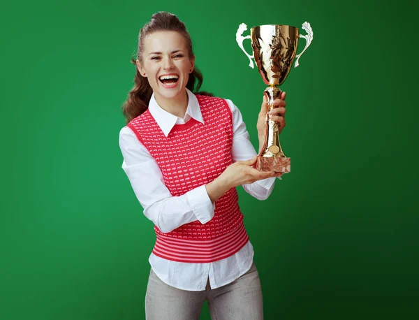 Felice studente sano mostrando calice d'oro su sfondo verde — Foto Stock