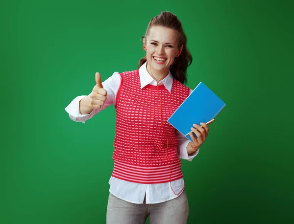 Estudiante en auriculares con un cuaderno azul y pluma de oro showin — Foto de Stock