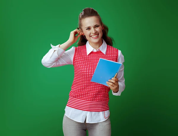 Uśmiechający się student w słuchawkach z niebieski notatnik i złote pióro — Zdjęcie stockowe