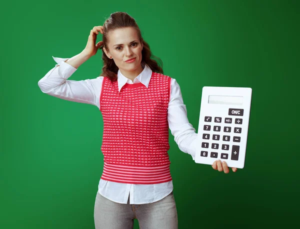 Doubting student with big white calculator scratching head — Stock Photo, Image