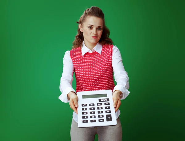 Estudante mulher dando grande calculadora branca isolado no verde — Fotografia de Stock