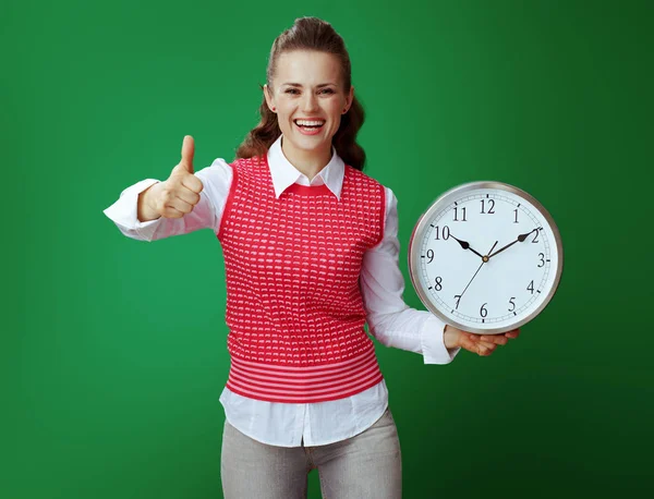 Happy student woman with white round clock showing thumbs up — Stock Photo, Image