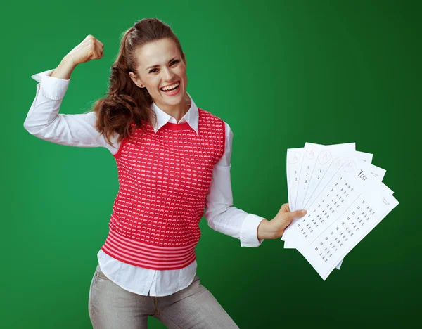 Щаслива жінка-вчителька, що показує результати тесту А+ та біцепси — стокове фото