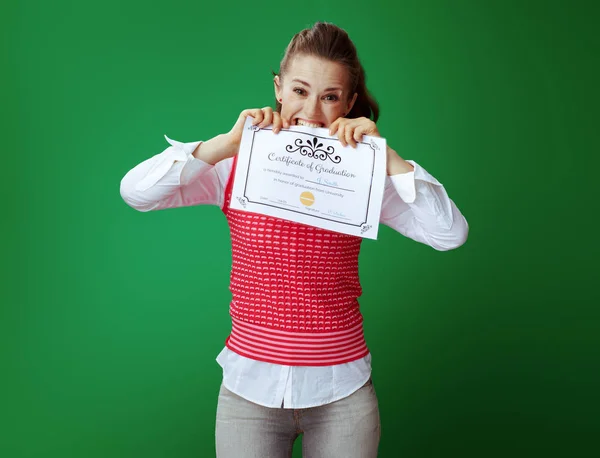 Annoyed fit learner woman biting Certificate of Graduation — Stock Photo, Image