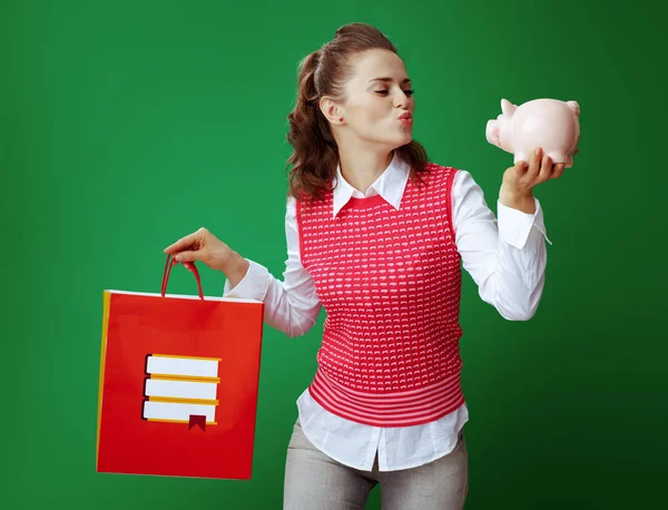 Studentin mit roter Einkaufstasche mit Büchern gibt Luftkuss — Stockfoto