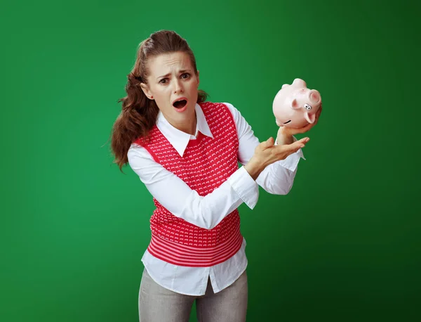 Stressed young student woman shaking pink piggy bank — Stock Photo, Image