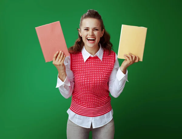 Felice donna studente in forma che mostra due libri rossi e gialli — Foto Stock