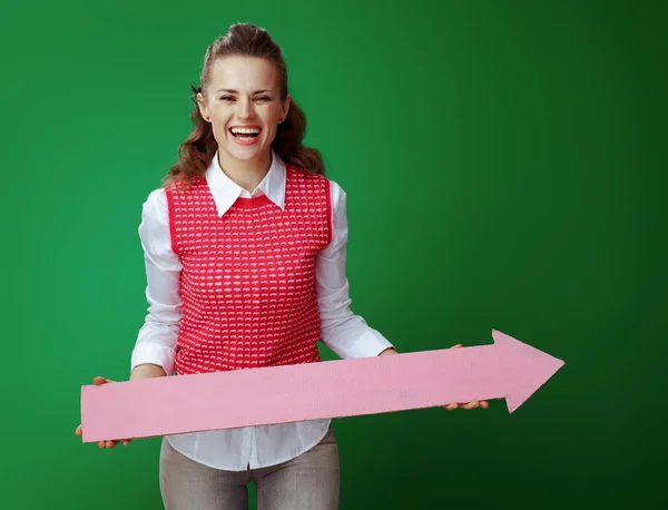 Sonriente aprendiz mujer sosteniendo gran flecha rosa apuntando a la derecha —  Fotos de Stock