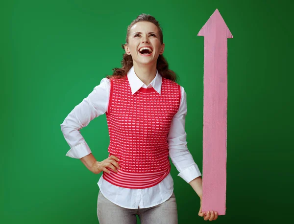 Sonriente aprendiz mujer sosteniendo gran flecha rosa apuntando hacia arriba —  Fotos de Stock