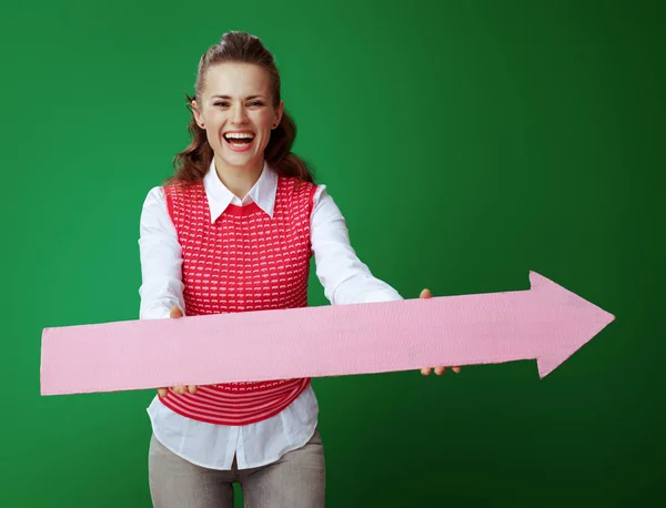 Feliz ajuste aprendiz mulher dando grande seta rosa apontando para a direita — Fotografia de Stock