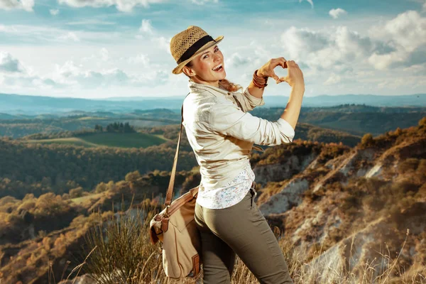 Femme en randonnée estivale en Toscane montrant les mains en forme de coeur — Photo