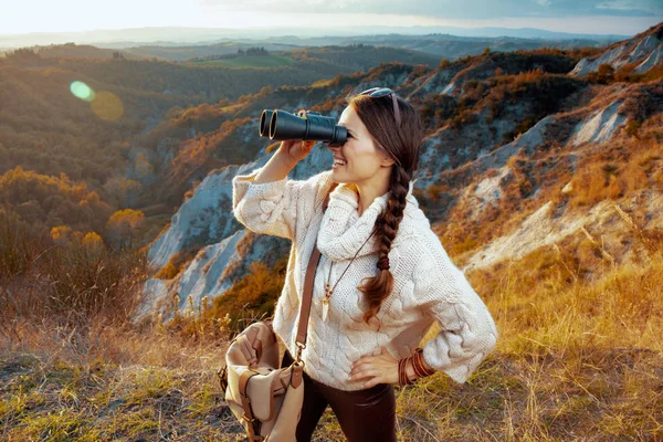 Woman hiker in Tuscany looking into distance through binoculars — Stock Photo, Image