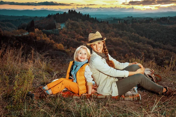 Souriant en forme mère et enfant voyageurs assis sur la couverture — Photo