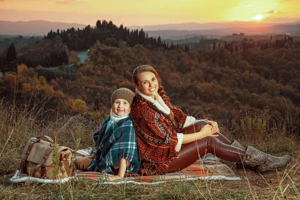 Feliz ajuste madre e hija sentado en manta —  Fotos de Stock