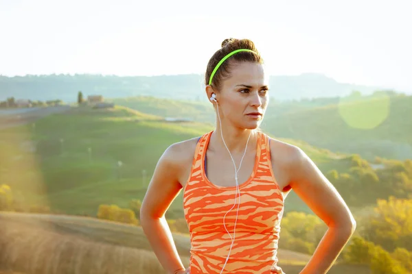 active woman jogger in Tuscany, Italy looking into distance