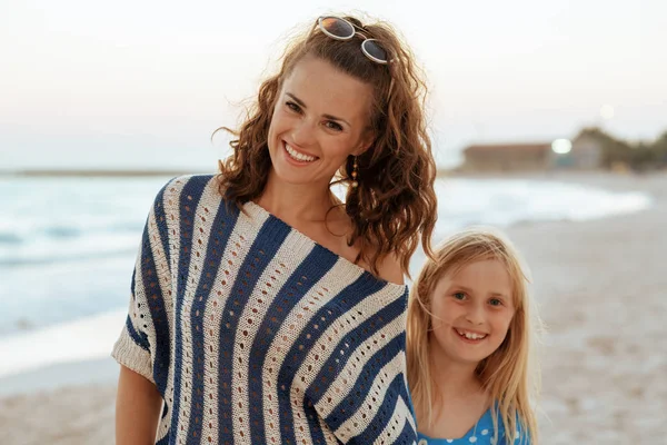 Glimlachen van moeder en kind reizigers op strand in avond — Stockfoto