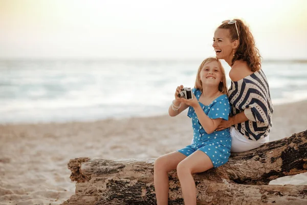 Mor och dotter turister sitter på en trä hake och tar — Stockfoto