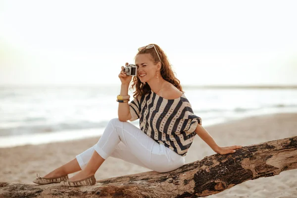 Женщина делает фотографии с ретро фотокамерой, сидя на w — стоковое фото