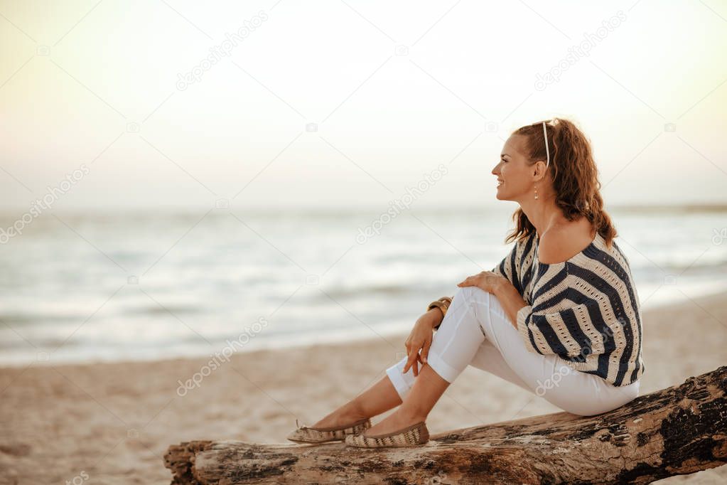 tourist woman looking into the distance while sitting on a woode