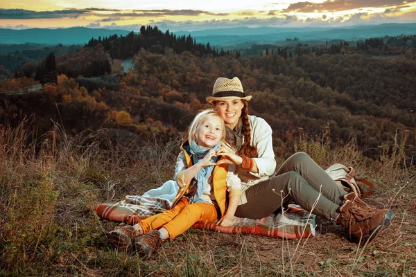 Madre e hijo mostrando las manos en forma de corazón mientras está sentado en bla —  Fotos de Stock