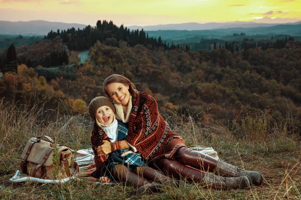 Matka a dítě turisty všeobjímající zatímco sedí na dece — Stock fotografie